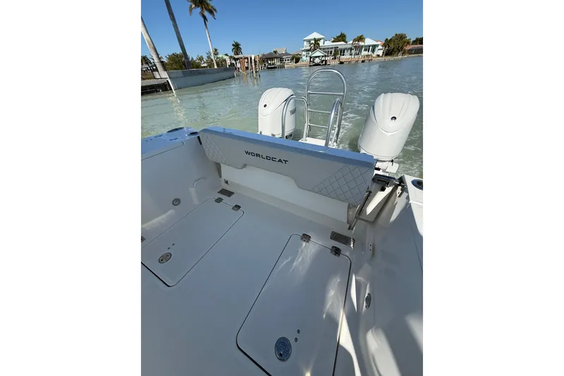 Slide: The Image of 2025 World Cat 260 DC-X boat with dual engines, docked near palm trees and waterfront homes. - 12