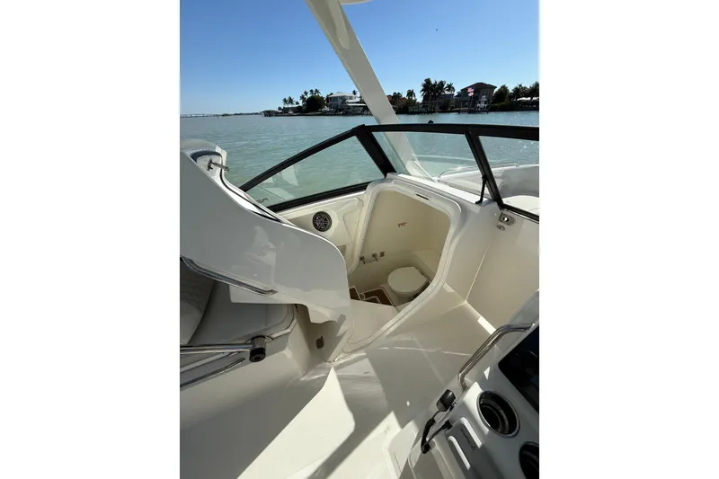 Slide: The Image of 2025 World Cat 260 DC-X boat interior with open cabin and toilet, on calm waters. - 14