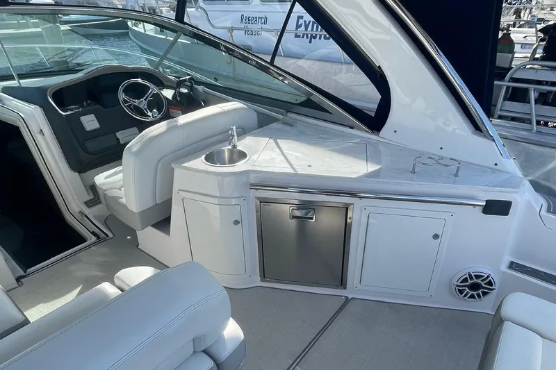 Slide: The Image of 2021 Regal 33 XO boat interior with helm, seating, and kitchenette area. - 11