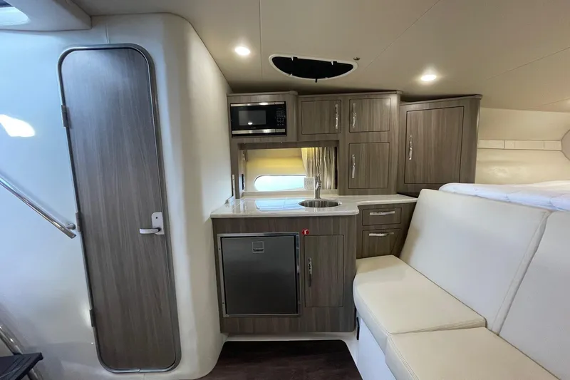 Slide: The Image of 2021 Regal 33 XO yacht interior with modern kitchenette and seating area. - 18