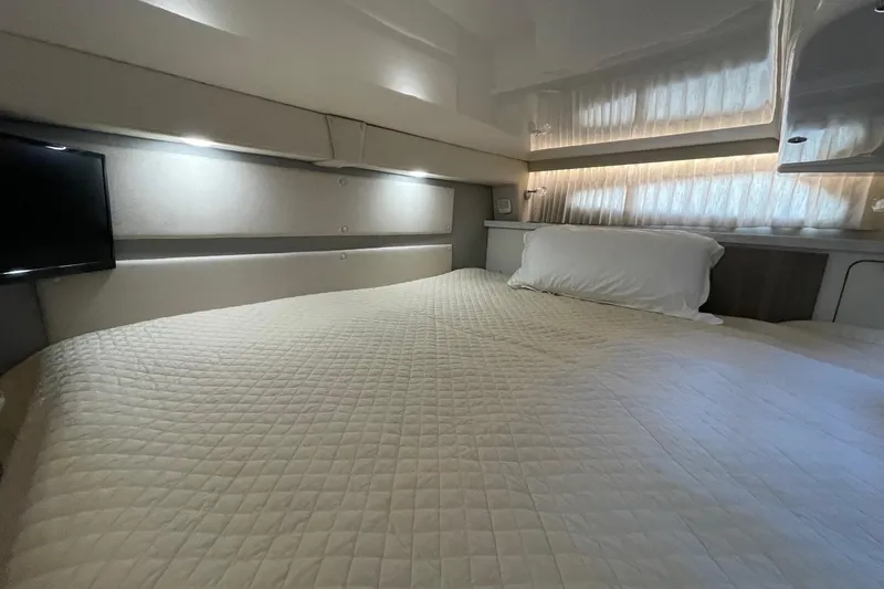 Slide: The Image of Luxurious cabin interior of 2021 Regal 33 XO yacht with cozy bedding and ambient lighting. - 21
