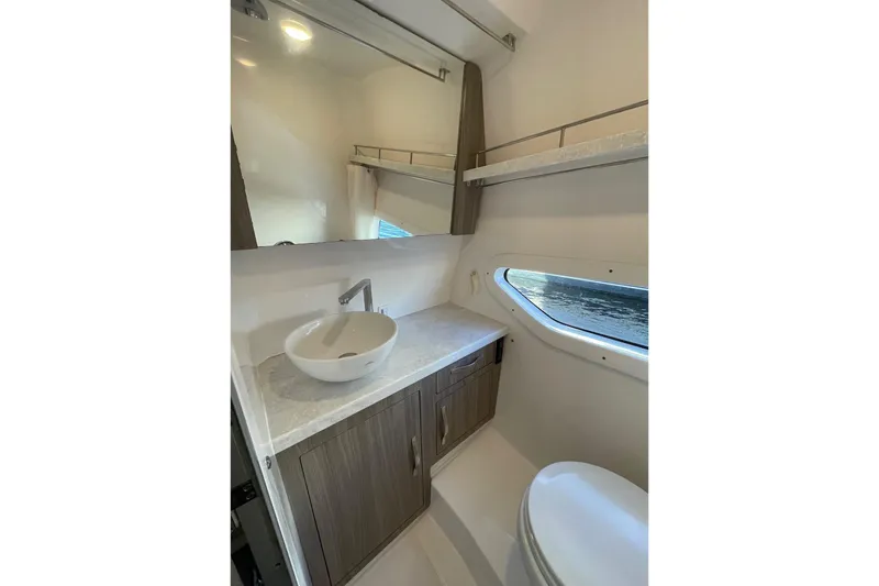 Slide: The Image of 2021 Regal 33 XO yacht bathroom with modern sink, mirror, and window view. - 23