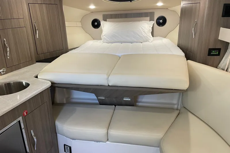 Slide: The Image of 2021 Regal 33 XO cabin interior with bed, seating, and kitchenette. - 24