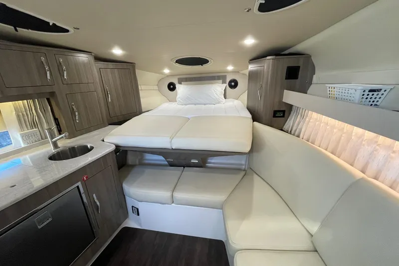 Slide: The Image of Luxurious interior of 2021 Regal 33 XO yacht with bed, kitchenette, and seating area. - 25