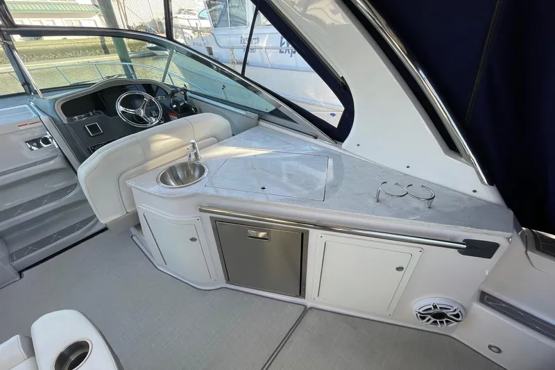 Slide: The Image of 2021 Regal 33 XO boat interior with helm, sink, and storage cabinets. - 7
