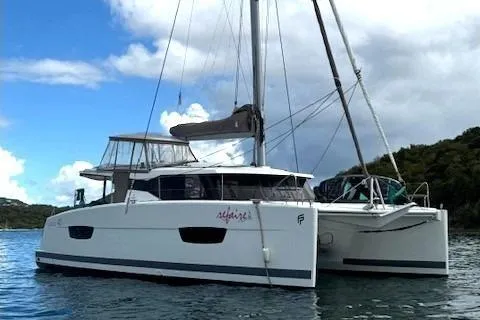 Slide: The Image of 2016 Fountaine Pajot Lucia 40 catamaran sailing on calm waters under a cloudy sky. - 104