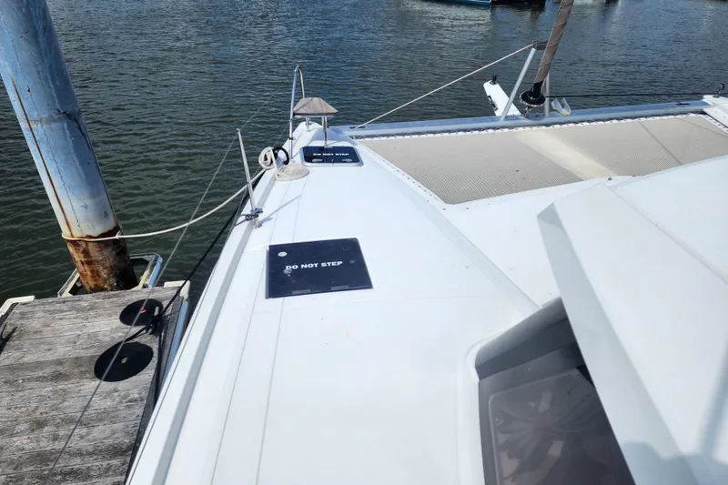 Slide: The Image of 2016 Fountaine Pajot Lucia 40 catamaran docked at marina, sunny day, "Do Not Step" sign visible. - 32