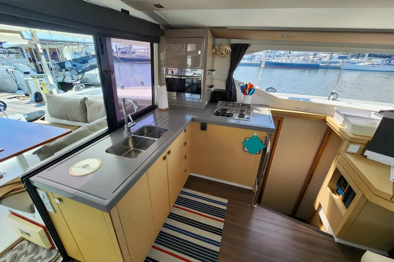 Slide: The Image of 2016 Fountaine Pajot Lucia 40 catamaran docked at a marina, clear enclosure view. - 45