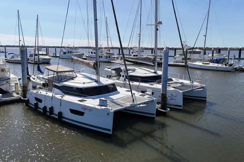 Slide: The Image of 2016 Fountaine Pajot Lucia 40 catamarans docked at a marina under clear skies. - 99