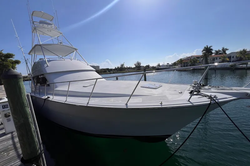 The Image of 2001 Hatteras 65 Convertible yacht docked in sunny marina setting. - 0