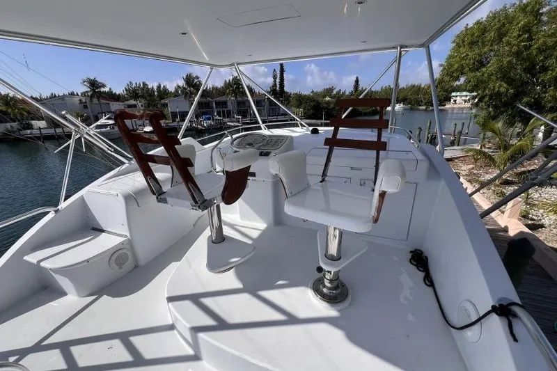 Slide: The Image of Flybridge of 2001 Hatteras 65 Convertible yacht with helm chairs and controls. - 12