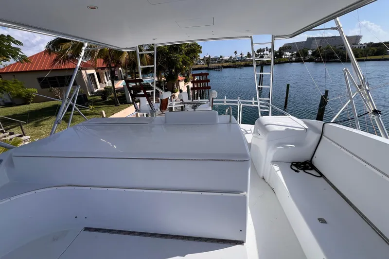 Slide: The Image of 2001 Hatteras 65 Convertible yacht deck with seating, overlooking serene waterfront. - 16