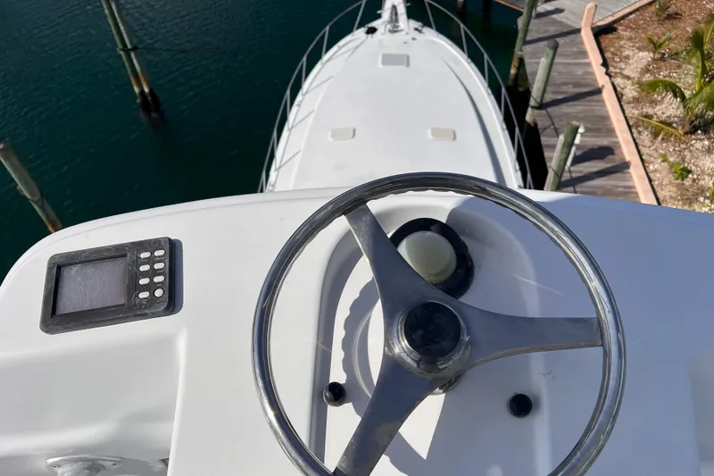 Slide: The Image of 2001 Hatteras 65 Convertible yacht helm with steering wheel and control panel. - 23