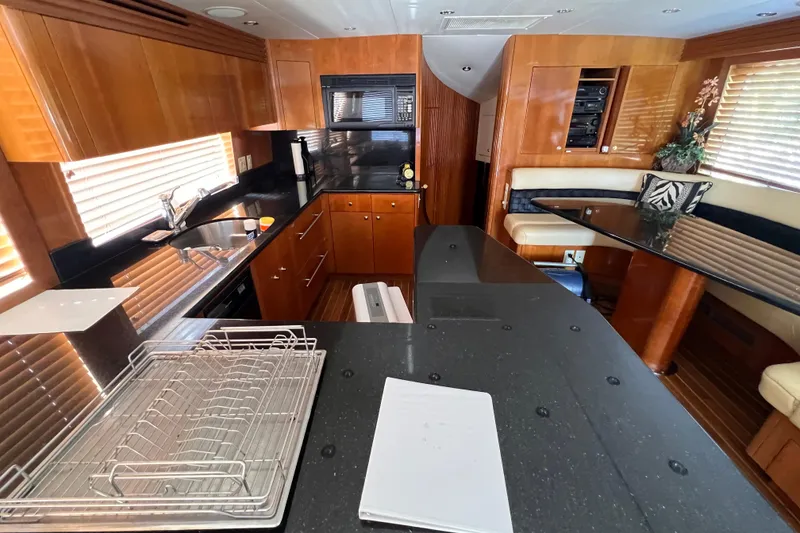 Slide: The Image of Luxurious kitchen interior of 2001 Hatteras 65 Convertible yacht with wood and black accents. - 40