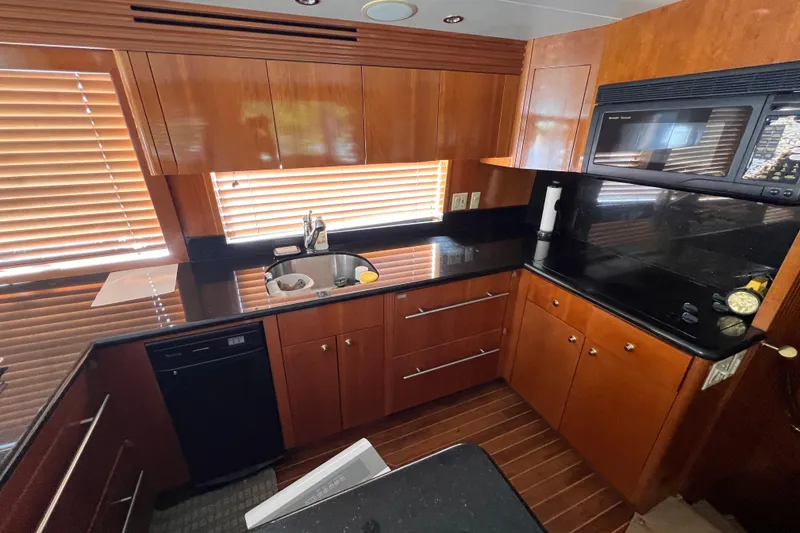 Slide: The Image of Luxurious kitchen interior of 2001 Hatteras 65 Convertible yacht with wooden cabinets and modern appliances. - 41