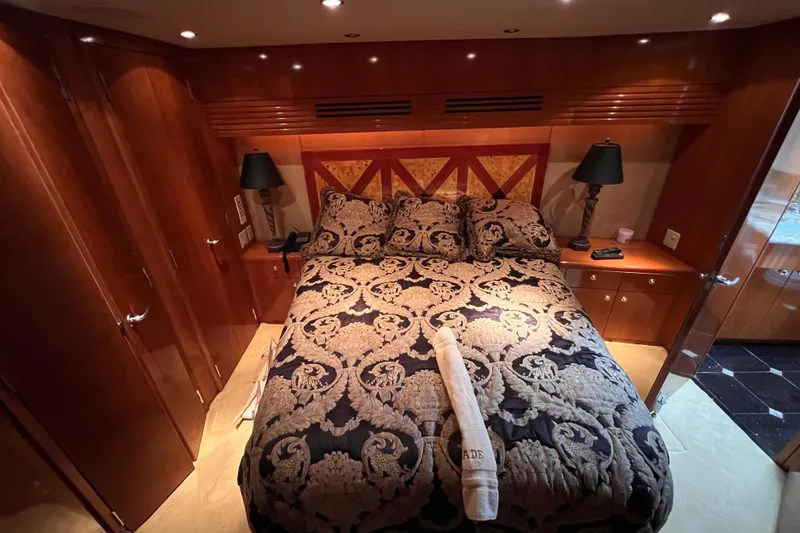 Slide: The Image of Luxurious bedroom interior of 2001 Hatteras 65 Convertible yacht with elegant bedding and wood finishes. - 47