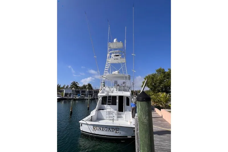 Slide: The Image of 2001 Hatteras 65 Convertible yacht docked, clear sky, marina background. - 5
