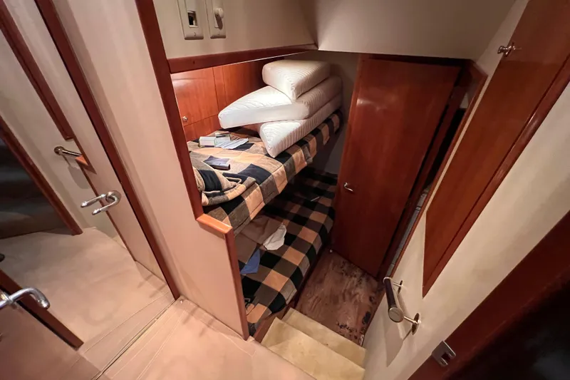 Slide: The Image of Interior of 2001 Hatteras 65 Convertible yacht with bunk beds and wooden finishes. - 54