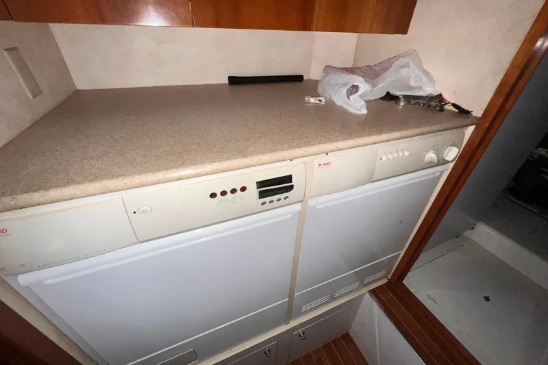 Slide: The Image of 2001 Hatteras 65 Convertible yacht interior with Asko appliances and wooden cabinetry. - 55