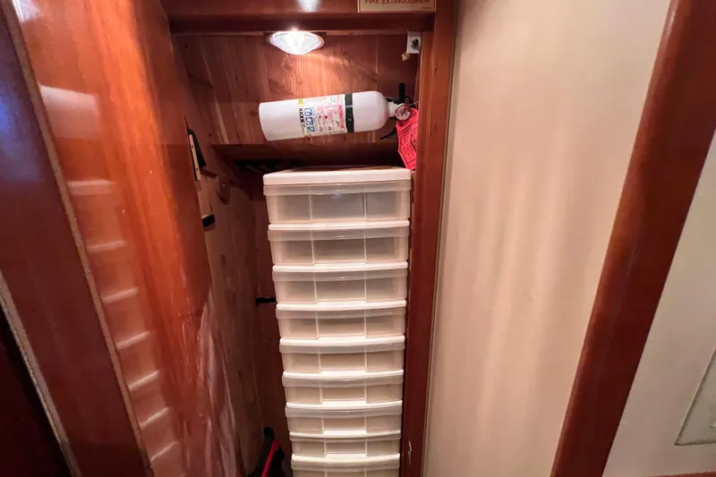 Slide: The Image of Storage area in 2001 Hatteras 65 Convertible with fire extinguisher and plastic drawers. - 58