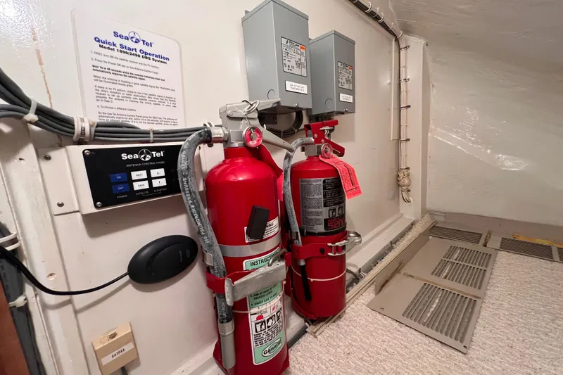 Slide: The Image of Fire extinguishers and control panel in 2001 Hatteras 65 Convertible yacht interior. - 59