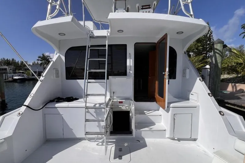 Slide: The Image of 2001 Hatteras 65 Convertible yacht stern with ladder and open door, docked in marina. - 6