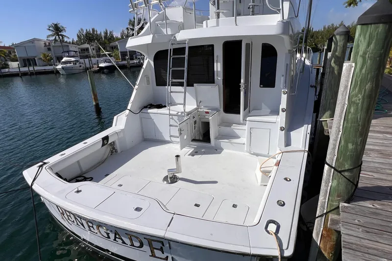 Slide: The Image of 2001 Hatteras 65 Convertible yacht docked, rear view with spacious deck and ladder. - 7