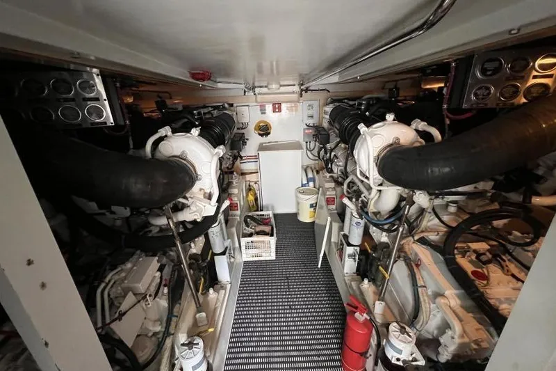Slide: The Image of Engine room of 2001 Hatteras 65 Convertible yacht, featuring dual engines and equipment. - 73