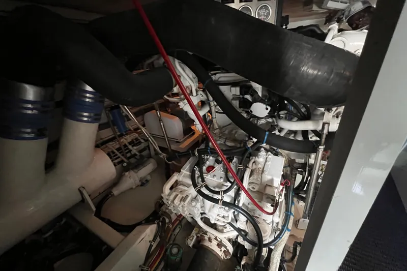 Slide: The Image of Engine room of 2001 Hatteras 65 Convertible yacht, showcasing complex machinery and piping. - 78