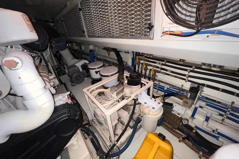 Slide: The Image of Engine room of 2001 Hatteras 65 Convertible yacht, showcasing mechanical components and wiring. - 83