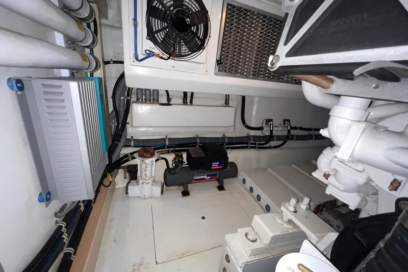 Slide: The Image of Engine room of 2001 Hatteras 65 Convertible yacht, featuring mechanical components and wiring. - 86