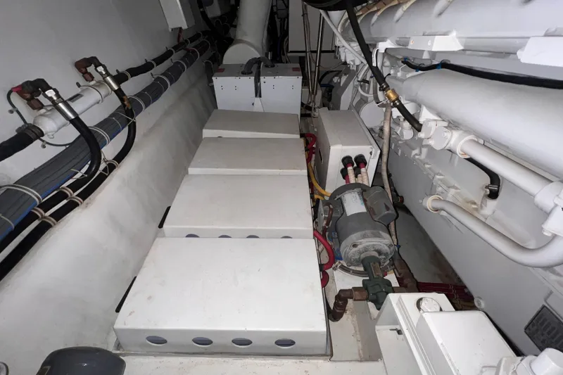 Slide: The Image of Engine room of a 2001 Hatteras 65 Convertible yacht, showcasing mechanical components and piping. - 88