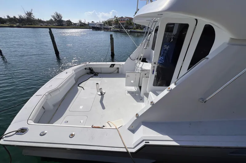 Slide: The Image of 2001 Hatteras 65 Convertible yacht docked, showcasing spacious deck and sleek design. - 9