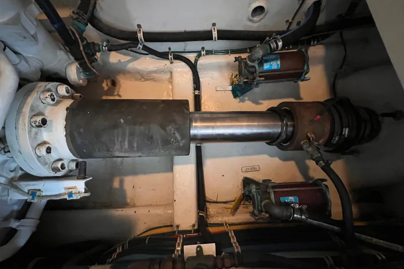 Slide: The Image of Engine room of 2001 Hatteras 65 Convertible yacht, showing mechanical components and piping. - 90