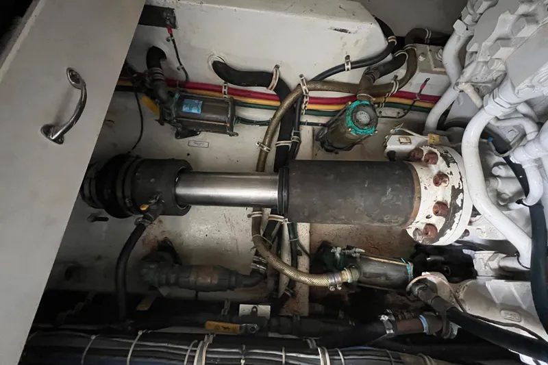 Slide: The Image of Engine room of a 2001 Hatteras 65 Convertible yacht, showcasing mechanical components and wiring. - 91