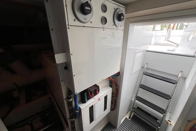 Slide: The Image of Engine room of 2001 Hatteras 65 Convertible yacht with control panels and ladder. - 92