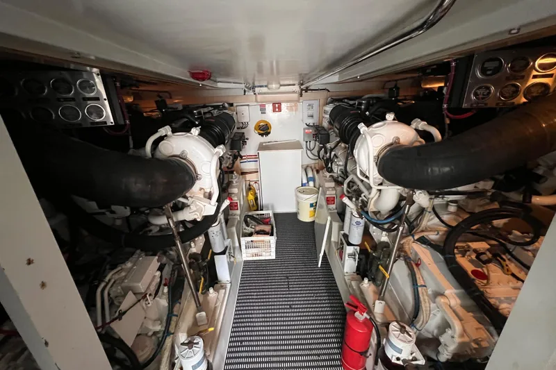 Slide: The Image of Engine room of 2001 Hatteras 65 Convertible yacht, featuring dual engines and equipment. - 94