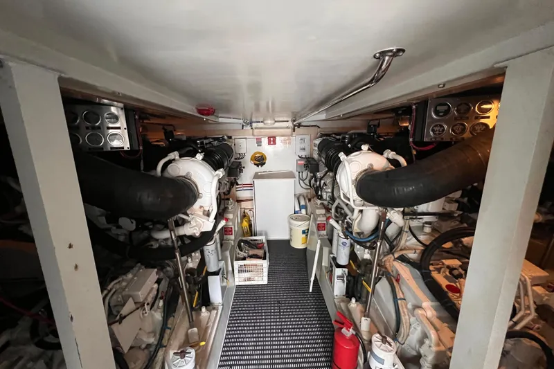 Slide: The Image of Engine room of a 2001 Hatteras 65 Convertible yacht, showcasing dual engines and control panels. - 95