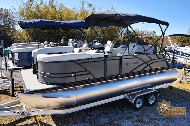 The Image of 2026 Sylvan Mirage X3 CLZ DH pontoon boat on trailer, outdoor display. - 0