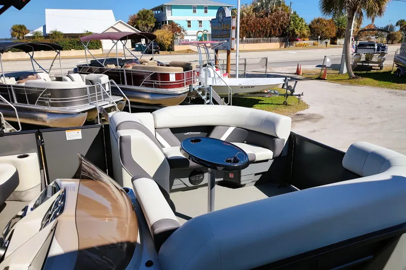 Slide: The Image of 2026 Sylvan Mirage X3 CLZ DH pontoon boat with luxurious seating and table, docked outdoors. - 8