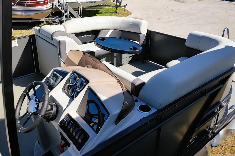 Slide: The Image of 2026 Sylvan Mirage X3 CLZ DH pontoon boat interior with steering console and seating area. - 9