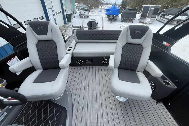 Slide: The Image of 2026 Harris Sunliner 230 boat interior with two gray captain chairs and textured flooring. - 12