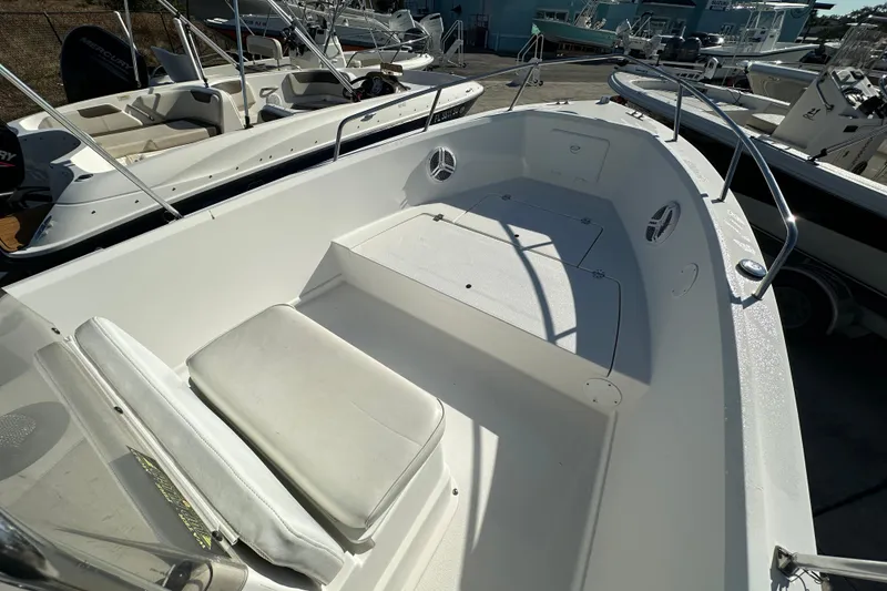 Slide: The Image of 2001 Aquasport 200 Osprey boat interior with seating and storage, docked among other boats. - 6