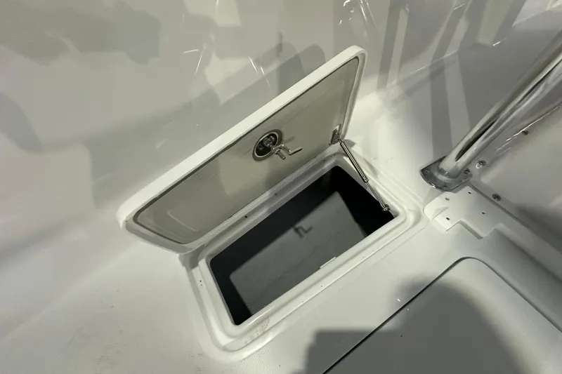 Slide: The Image of Open storage compartment on 2026 Bluewater 23T boat, featuring a secure latch. - 10