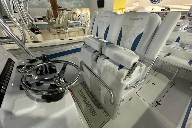Slide: The Image of 2026 Bluewater 23T boat interior with steering wheel and cushioned seating. - 13