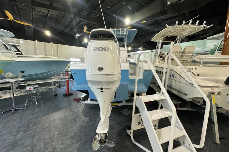 Slide: The Image of 2026 Bluewater 23T boat with 300 HP engine displayed indoors. - 4