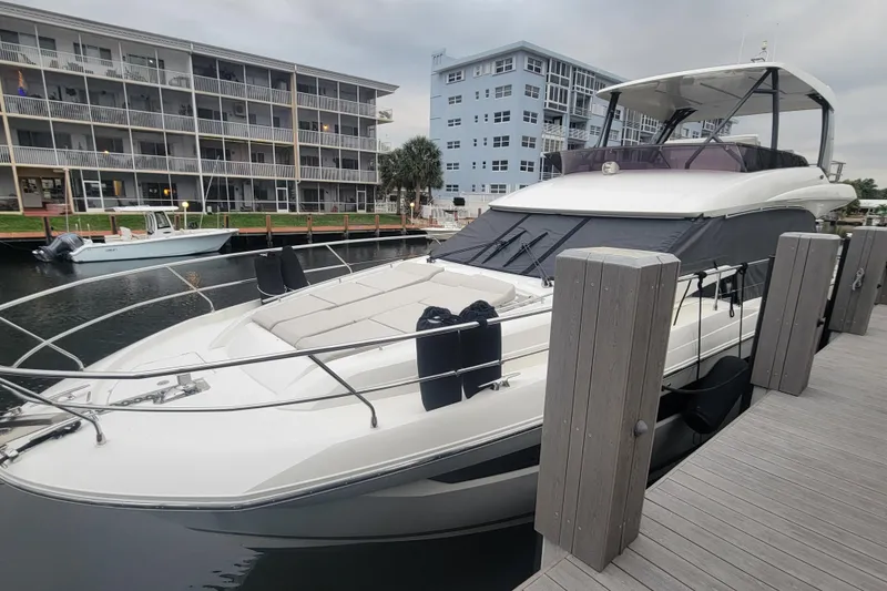 The Image of 2018 Prestige 520 yacht docked near waterfront apartments. - 1
