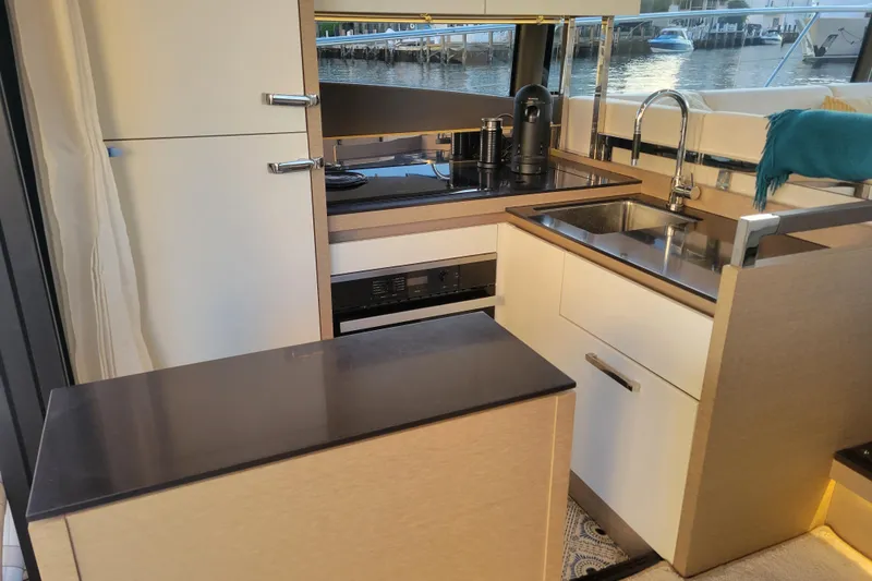 Slide: The Image of Bow of 2018 Prestige 520 yacht docked by waterfront with palm trees. - 11