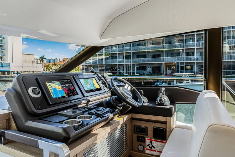 Slide: The Image of Prestige 520 yacht helm with navigation screens, steering wheel, and controls, 2018 model. - 29