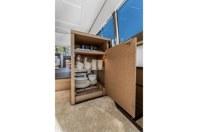 Slide: The Image of Open cabinet with dishes and cups inside a 2018 Prestige 520 yacht interior. - 33
